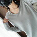 Women's grey V-neck long sleeve knitwear pullover on a hanger