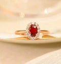 Gold Pigeon women's silver ring with red gemstone and floral gold inlaid pattern.