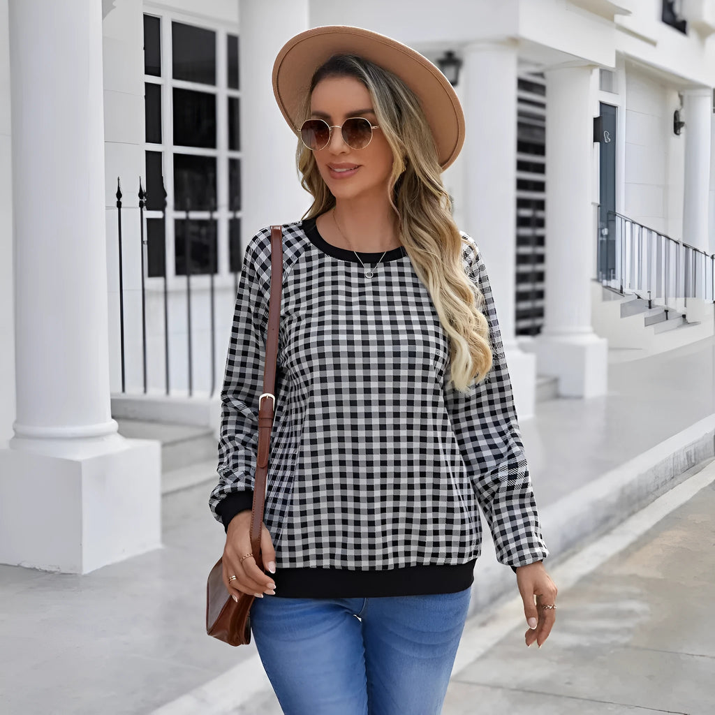 Black long sleeve pullover sweater with plaid stripes and printed pattern on a mannequin.