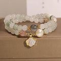 Women's crystal bracelet with a large green ginkgo leaf pendant, gold metalwork, and sparkling rhinestones.