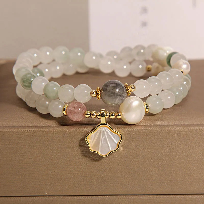 Women's crystal bracelet with a large green ginkgo leaf pendant, gold metalwork, and sparkling rhinestones.
