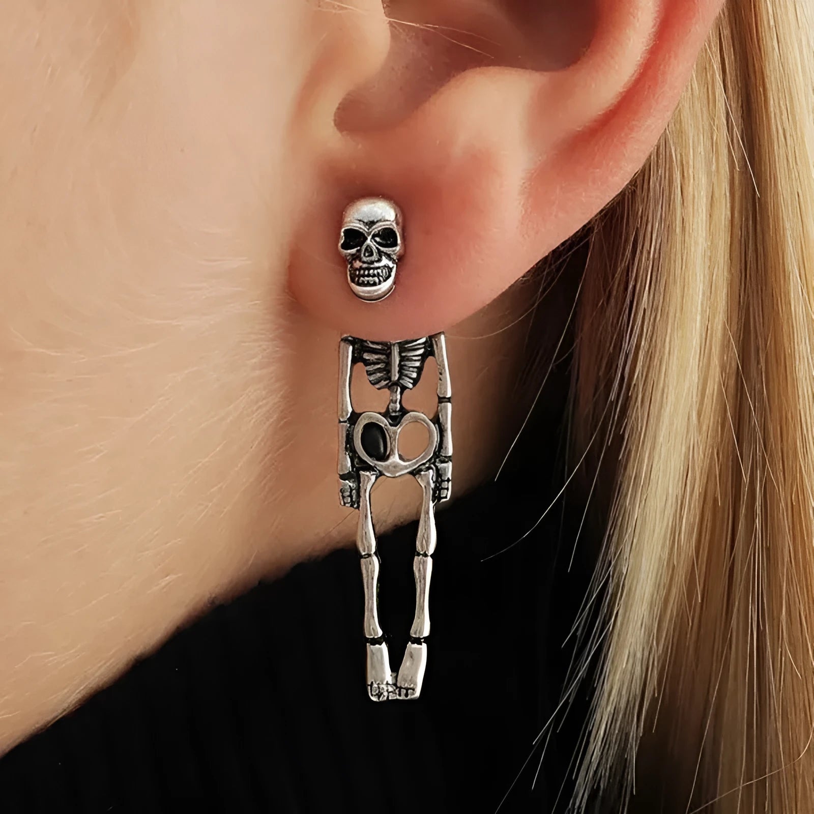 Gold and silver skull detachable stud earrings with skeleton design on white background