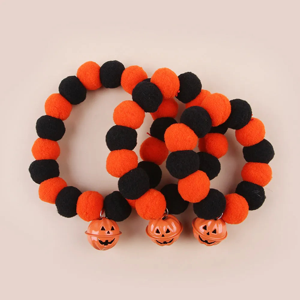 Halloween pet collar with orange pumpkin charm on black and white patterned nylon strap.