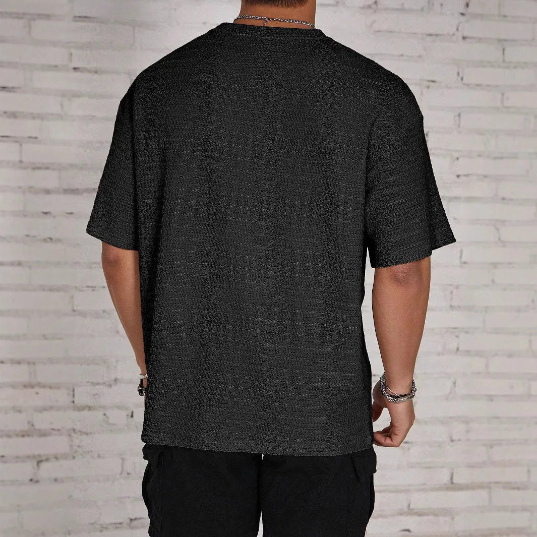 Man wearing a light blue loose fit slim style round neck short sleeve T-shirt