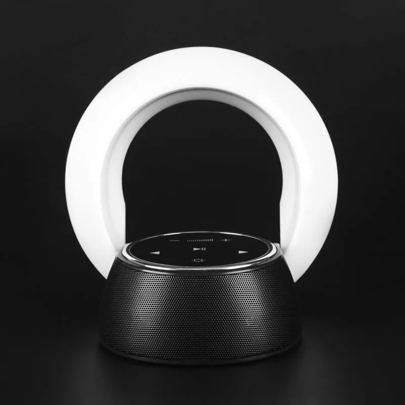 A blue and white foldable Bluetooth desk lamp with integrated speaker and touch controls on a wooden desk.