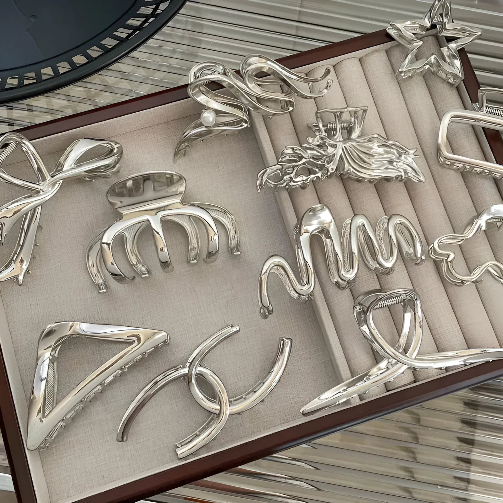 Assortment of silver metal hair barrettes and claw clips in various Korean-style designs on a white background.