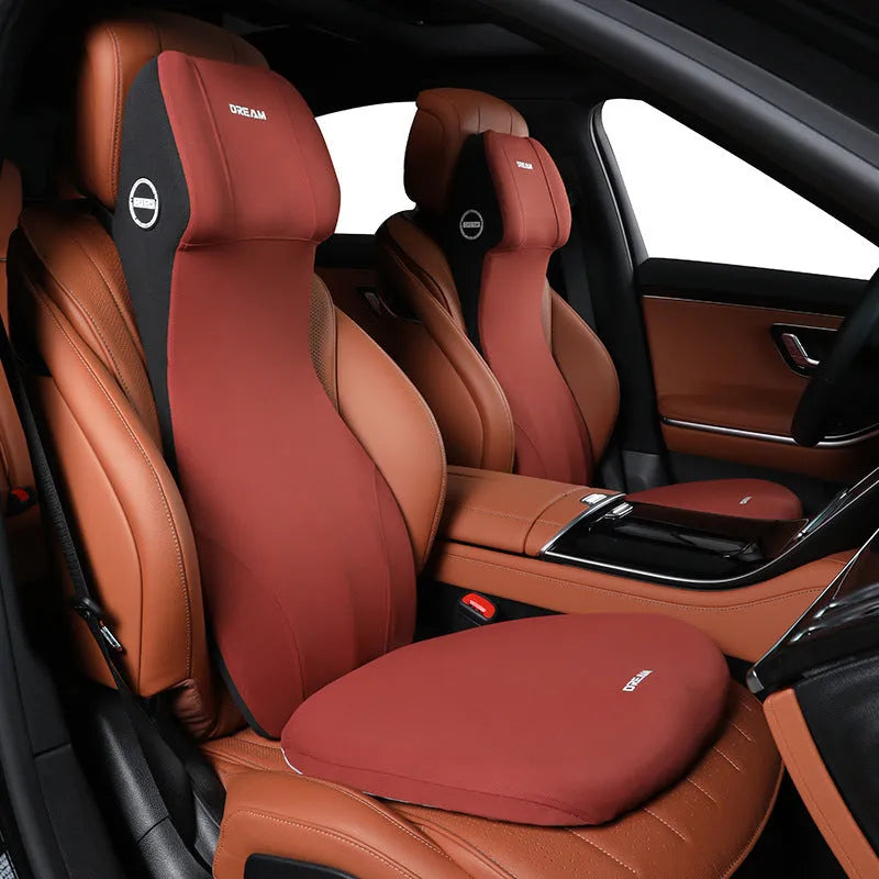 Black memory foam automotive lumbar support cushion with integrated headrest on a car seat.