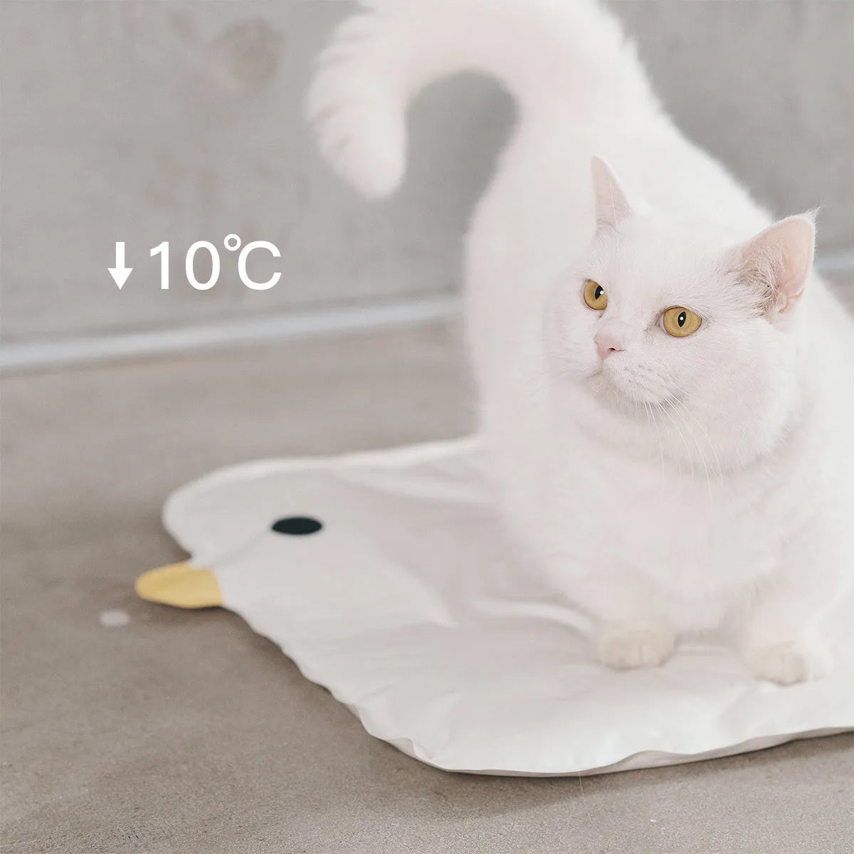 Yellow chick-shaped pet cooling mat on a wooden floor, showing non-stick fabric surface.