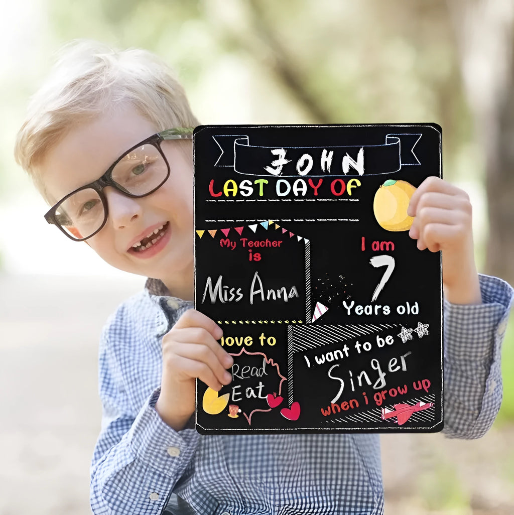 Wooden first day of school blackboard sign on a simple background.