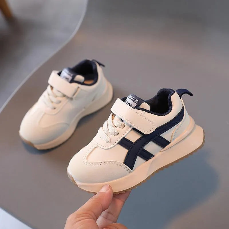 Children's solid-colour Velcro sneaker in beige with a rubber sole and synthetic leather upper.