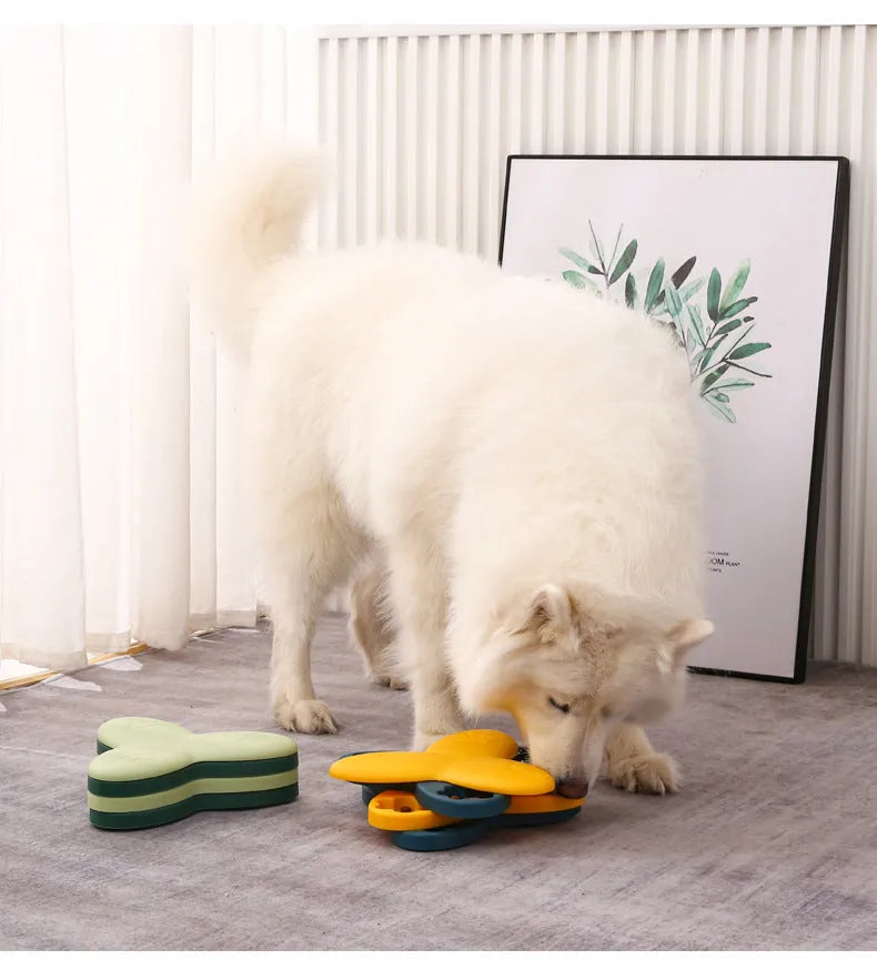 Green and yellow dog puzzle toy with rotatable treat dispenser and nine bone-shaped compartment covers