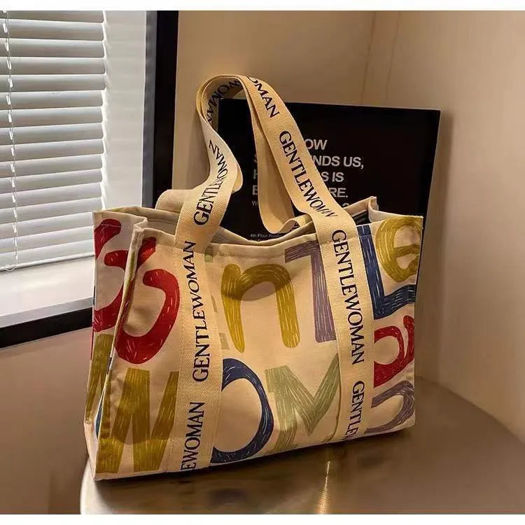 Women's large capacity canvas tote bag with printed design in three colour options.
