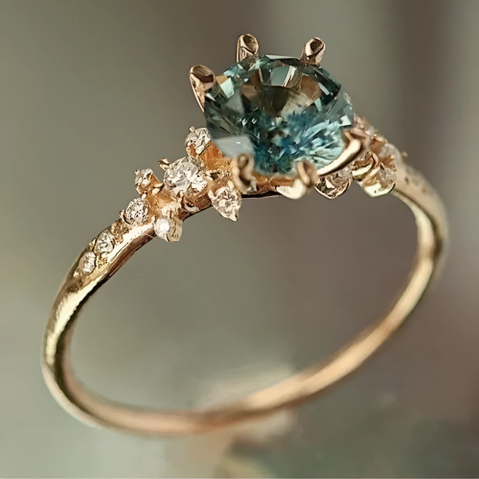Gold plated geometric ring with a claw-set zircon stone on a chamfered square pattern band.