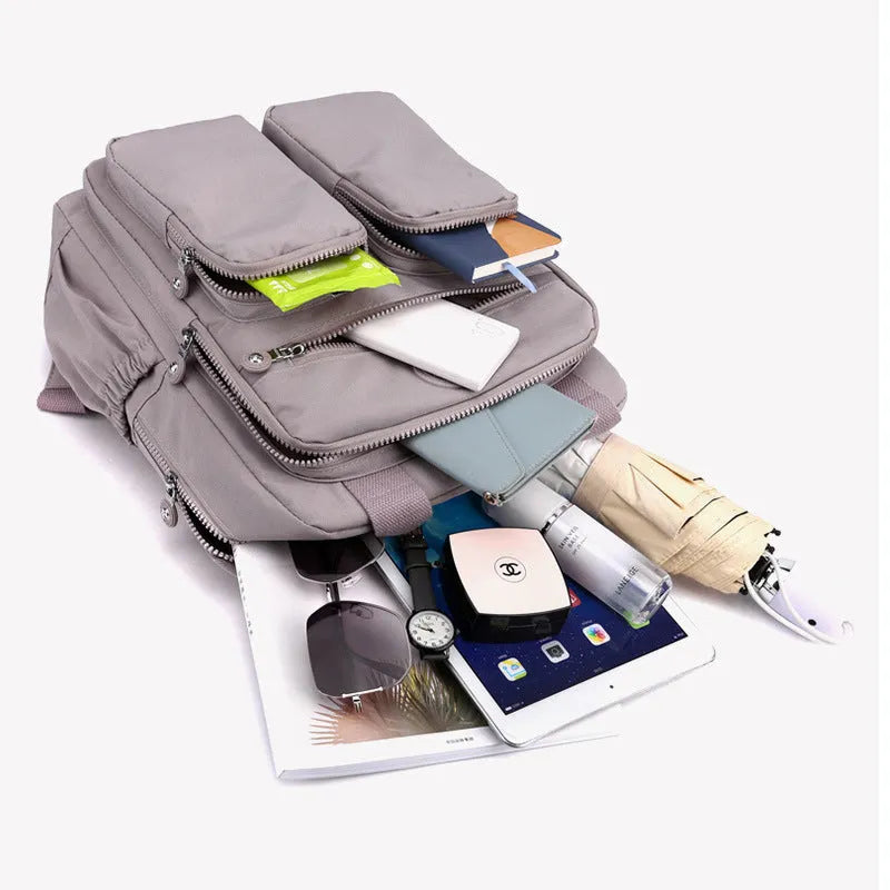 Large soft nylon waterproof backpack in grey, open to show internal laptop, camera, and phone compartments.