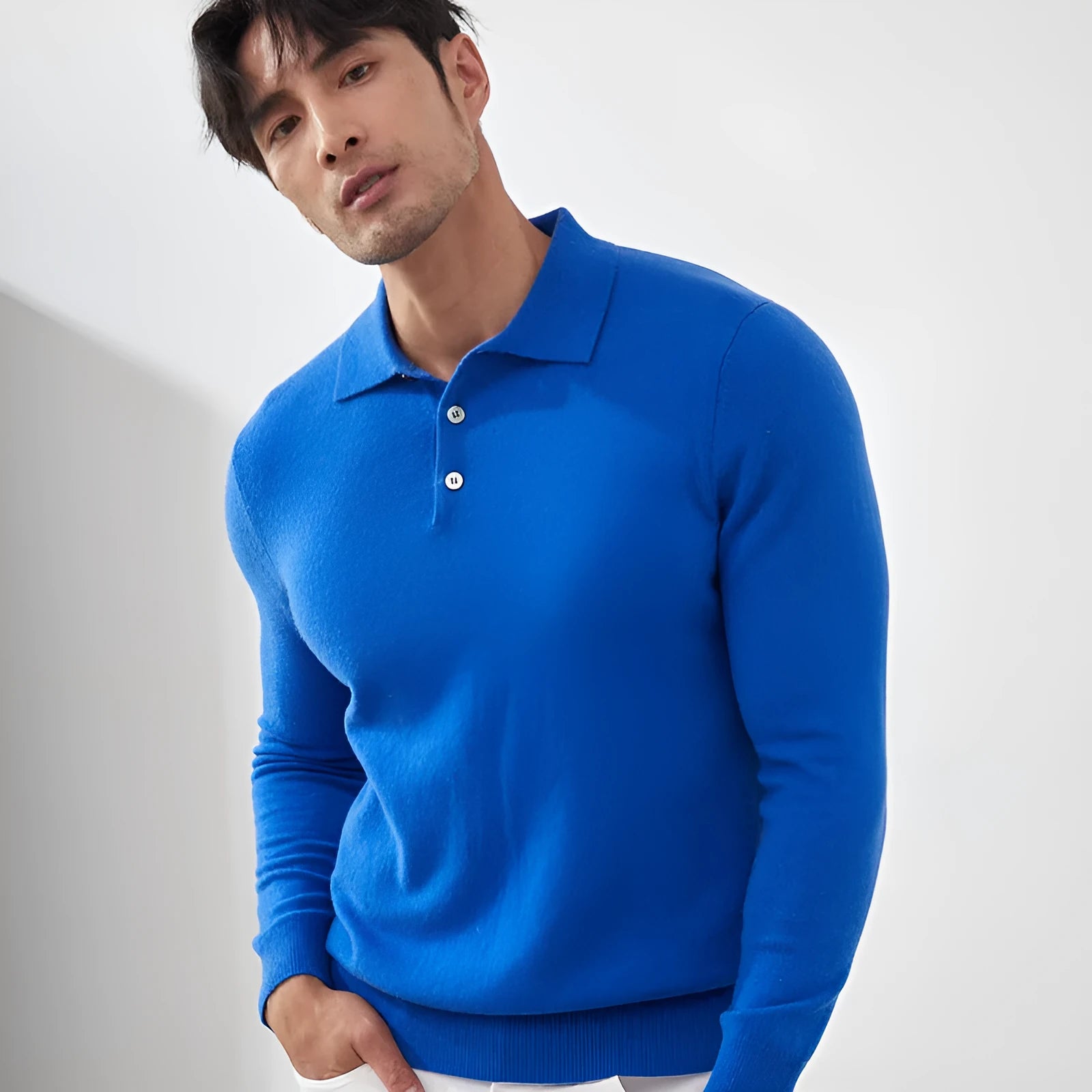 Man wearing a sapphire blue cashmere polo collar pullover sweater in a loose fit.