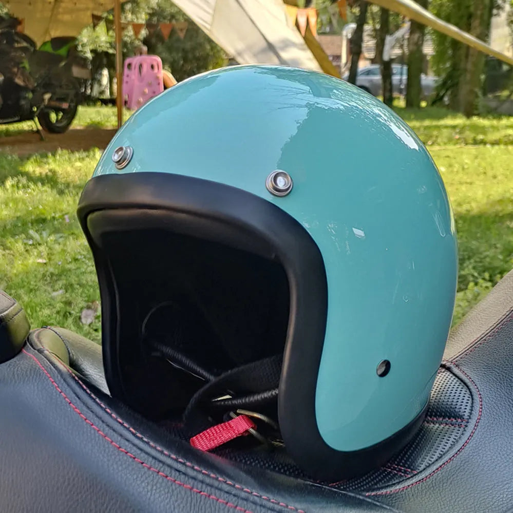 Retro style fibreglass half motorcycle helmet shown in a choice of colours like cement grey and matte black.