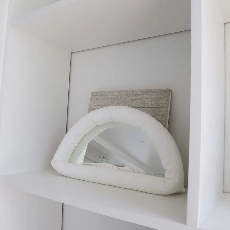 Hanging soft cotton-filled fabric mirror in solid colour on wall