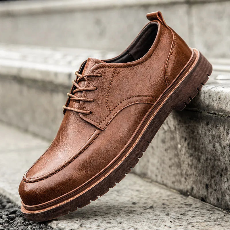 Men's black casual leather shoes with a round toe and flat rubber sole on a white background
