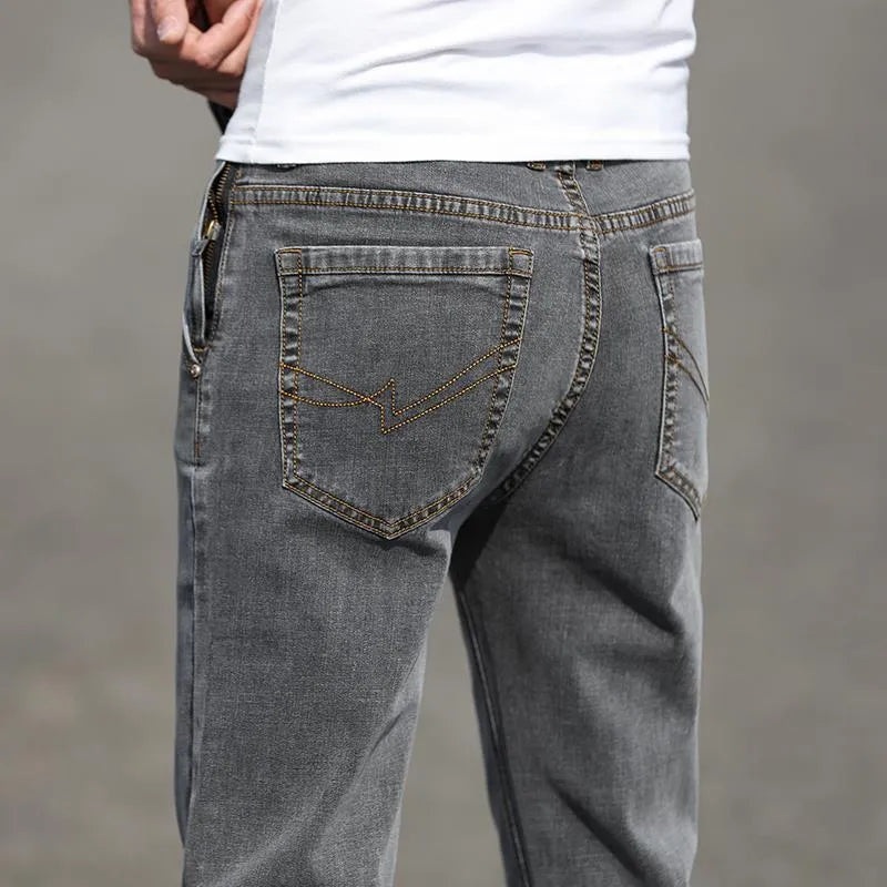 Men's smoky grey straight leg jeans with low waist design and zipper fly closure