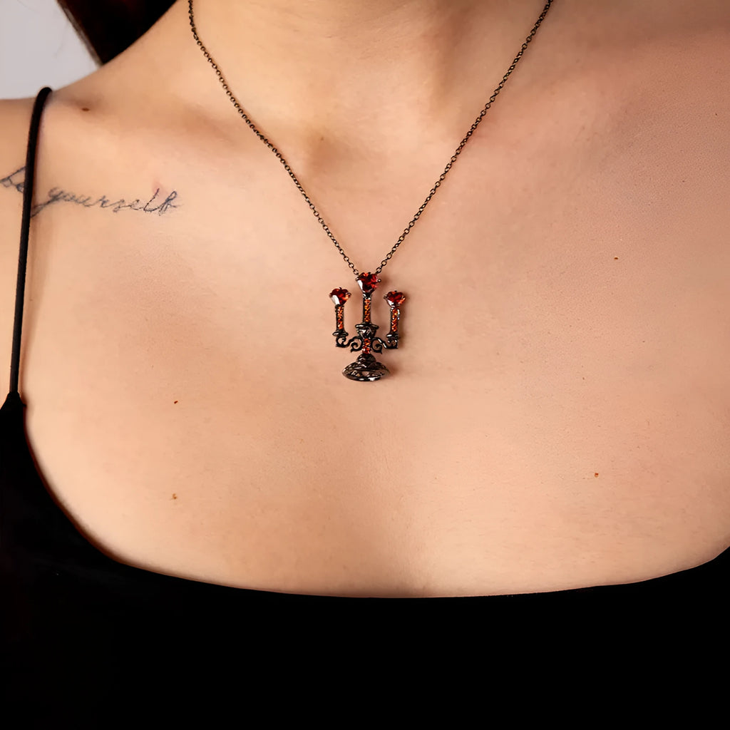 Zinc alloy gothic necklace with hollow candlestick pendant and cross chain on a dark background.