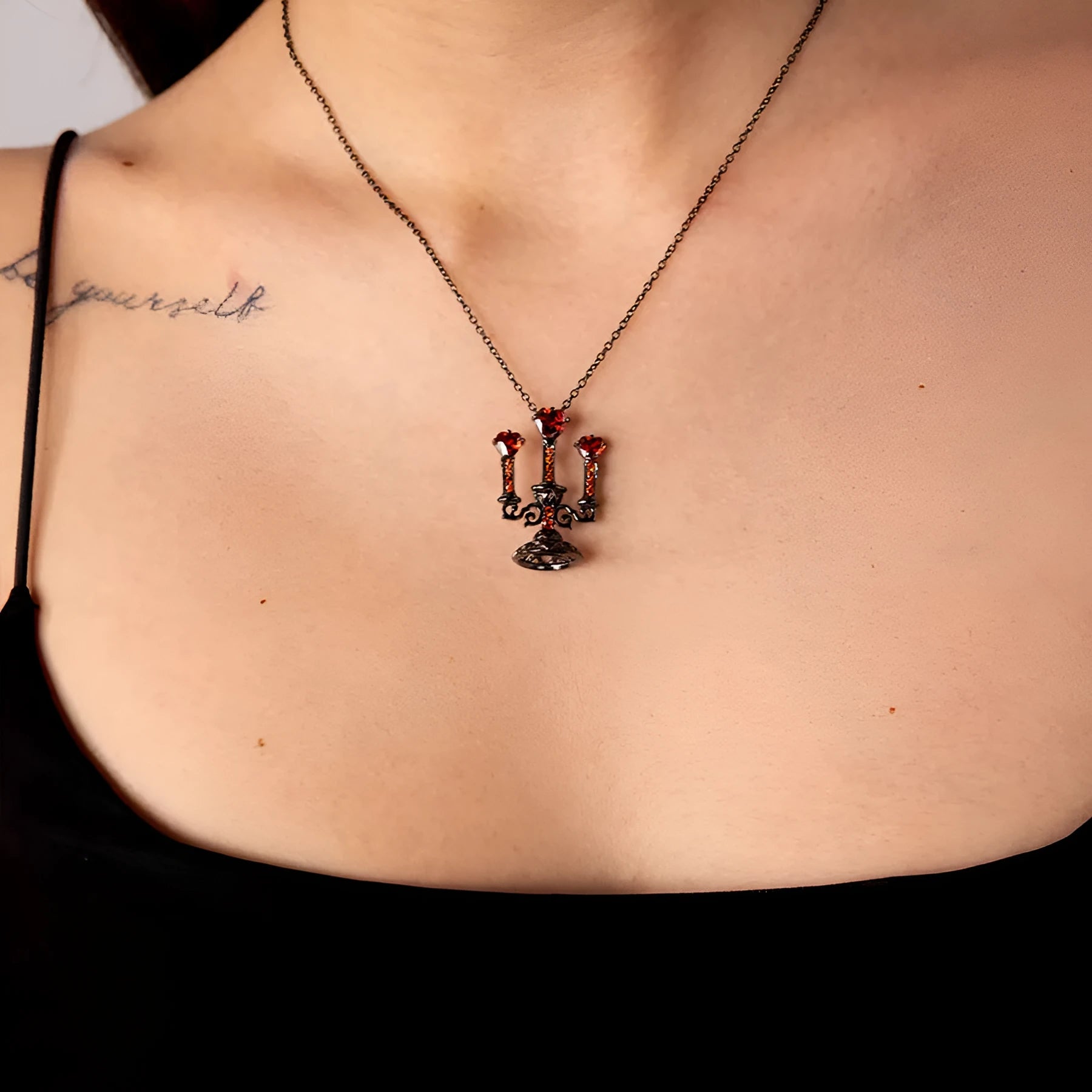 Zinc alloy gothic necklace with hollow candlestick pendant and cross chain on a dark background.