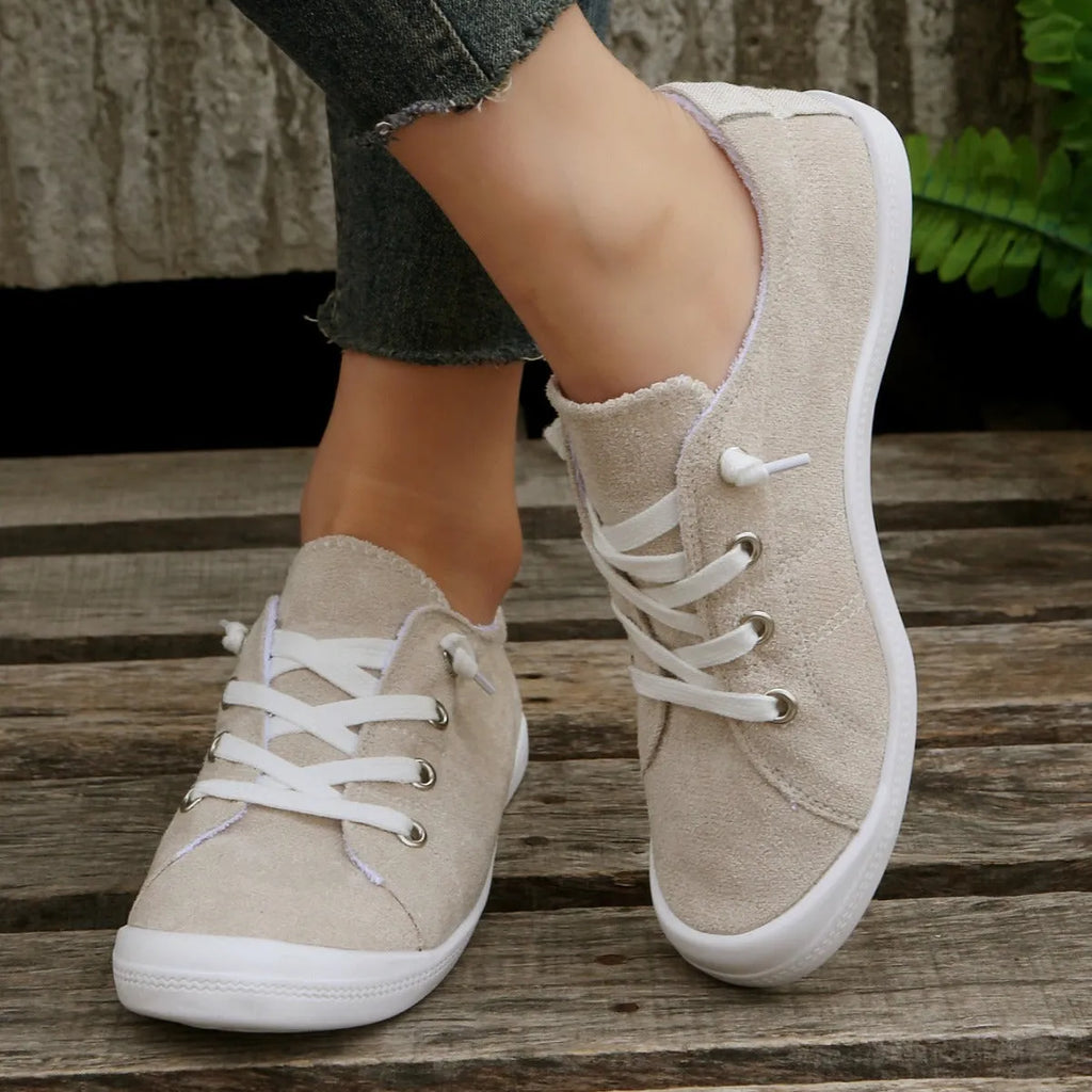 Women's creamy-white low-top fabric casual sneakers with a rubber sole on a neutral background.