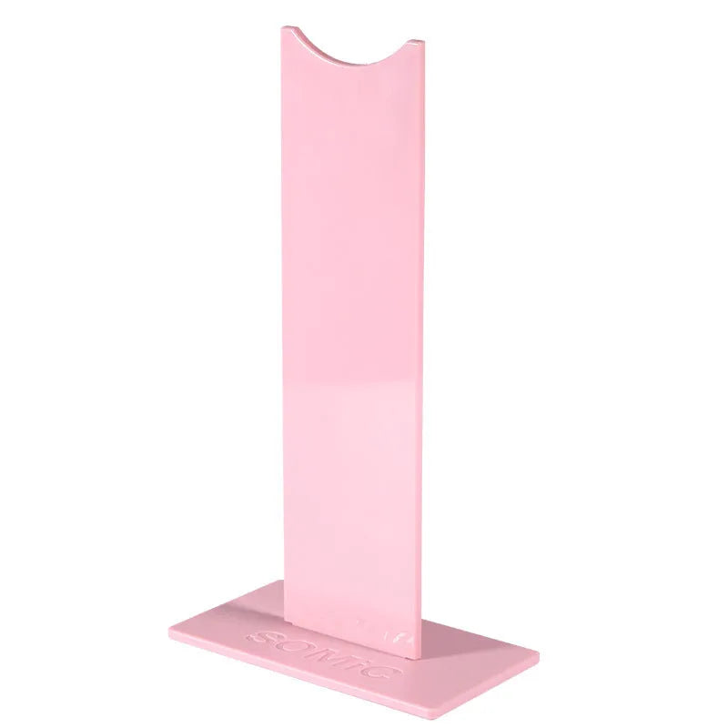 Pink detachable gaming headset stand with non-slip silicone base on a desk