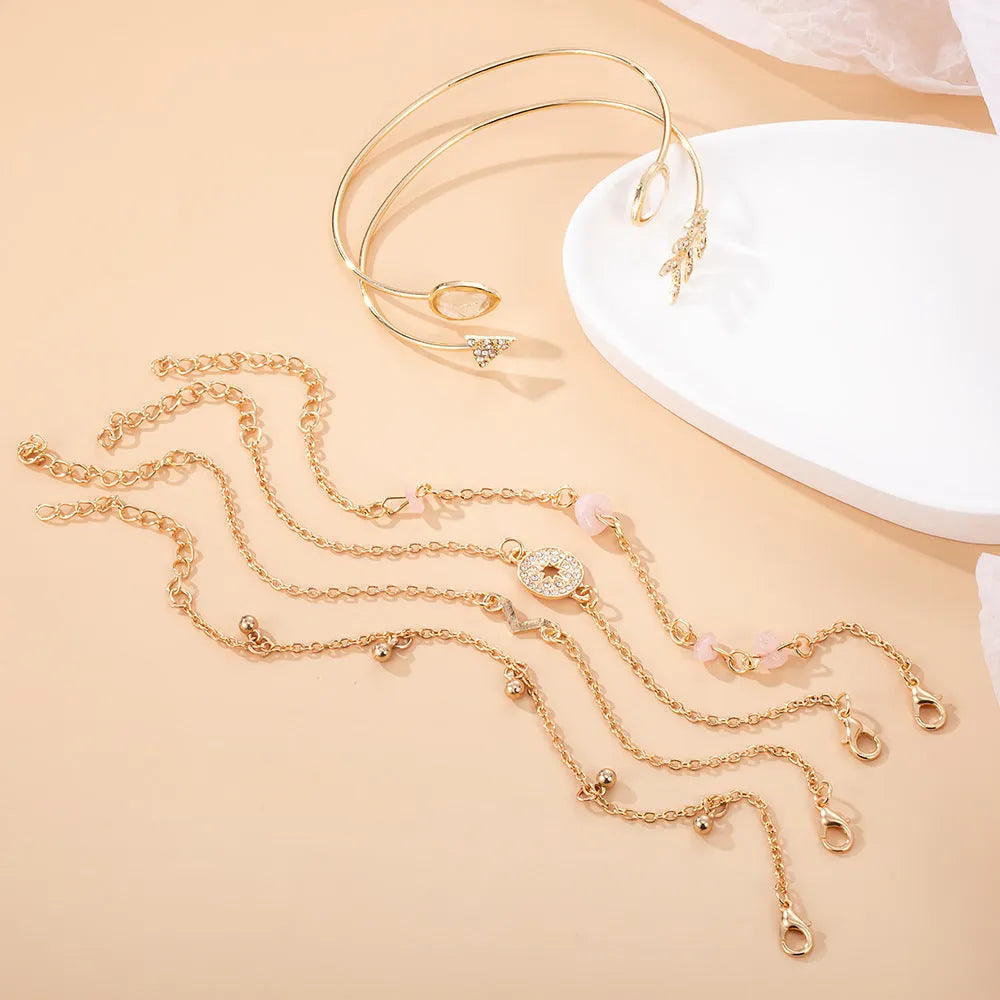Set of six gold fashion bracelets with water droplet, arrow, V-shape and drill designs.
