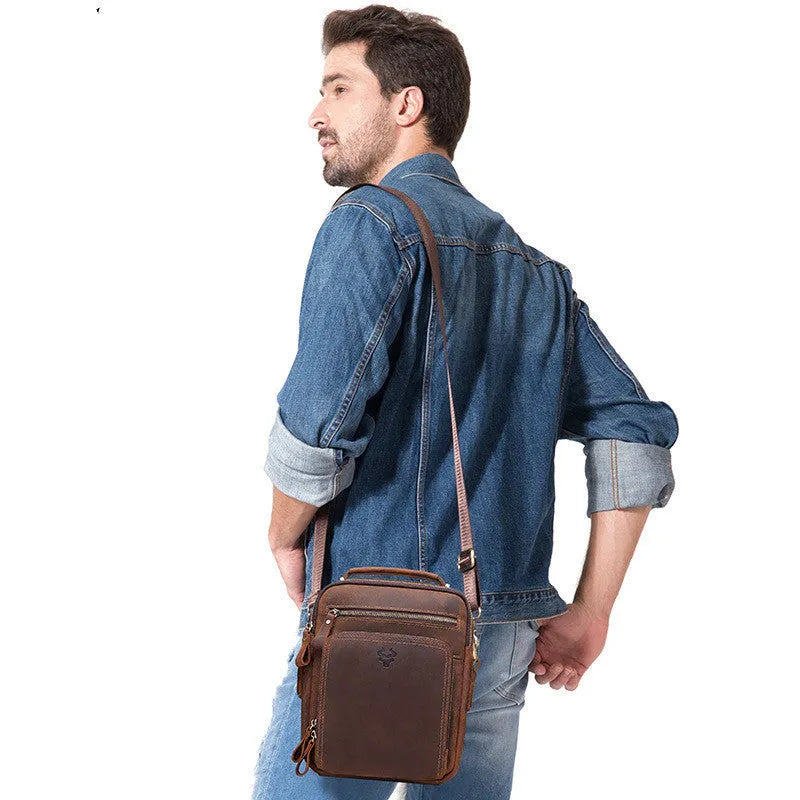 Men's brown Crazy Horse leather crossbody bag with single shoulder strap showing visible sewing lines