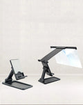 Black folding mobile phone screen amplifier with detachable holder on desktop