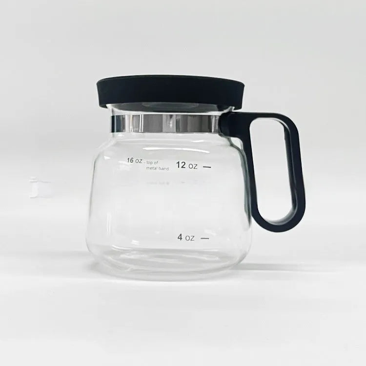 Transparent borosilicate glass coffee maker with black silicone cover and handle on a stovetop.