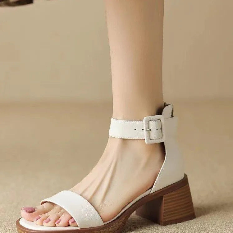 Women's white retro ankle-strap platform high heels with a round toe on a plain background.