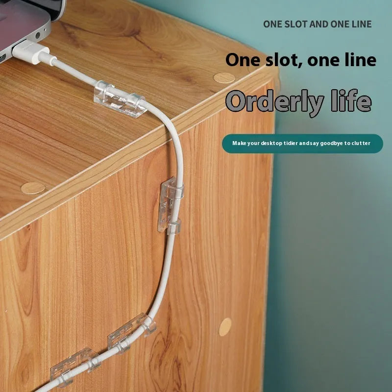 Transparent self-adhesive plastic wire holder snap clips for cable management on a white surface.