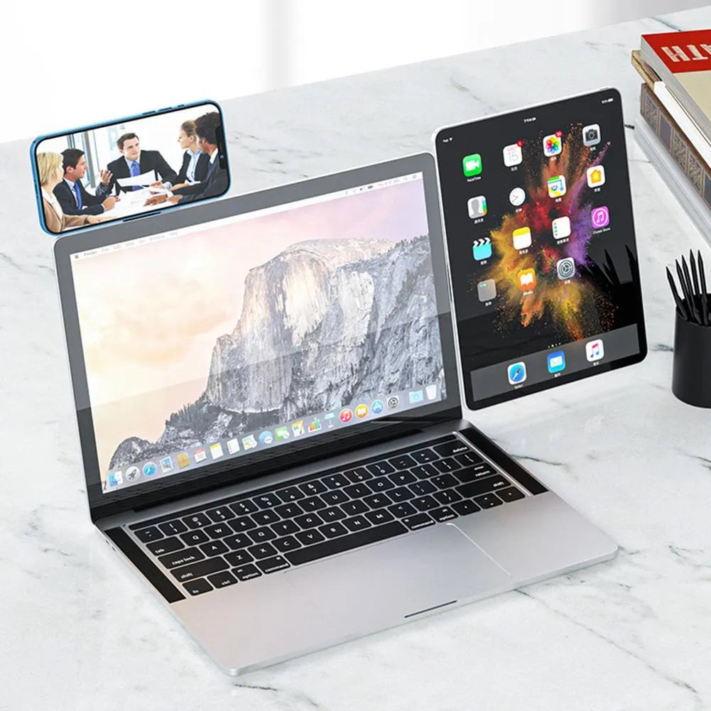 Black aluminium magnetic phone holder mounted on side of laptop screen with smartphone attached.