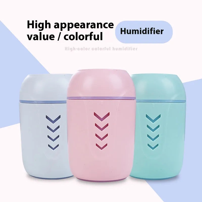Round blue portable air purifier and aromatherapy diffuser unit with USB cable on a wooden desk.