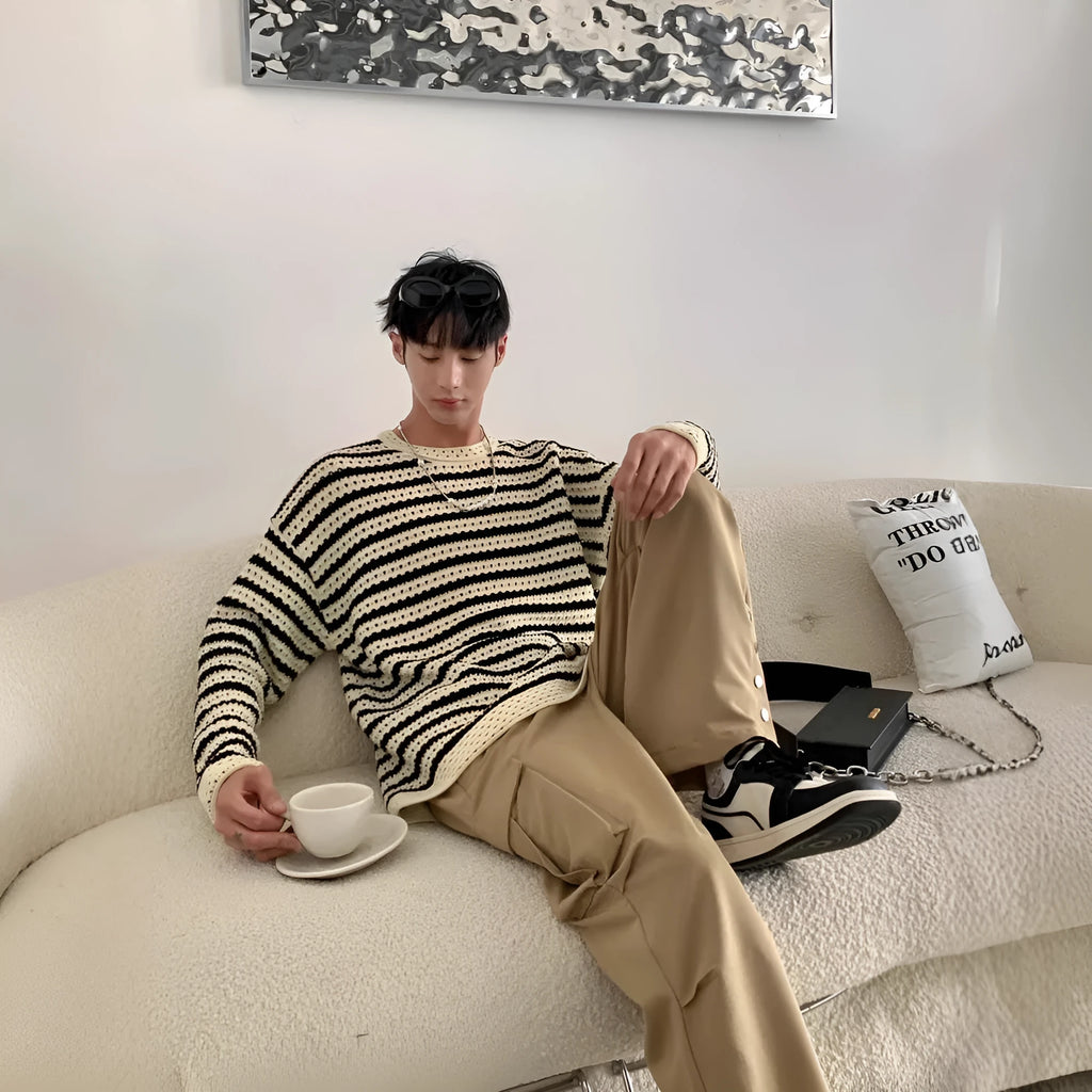 Men's black cotton blend long sleeve loose fit sweater on a hanger, front view