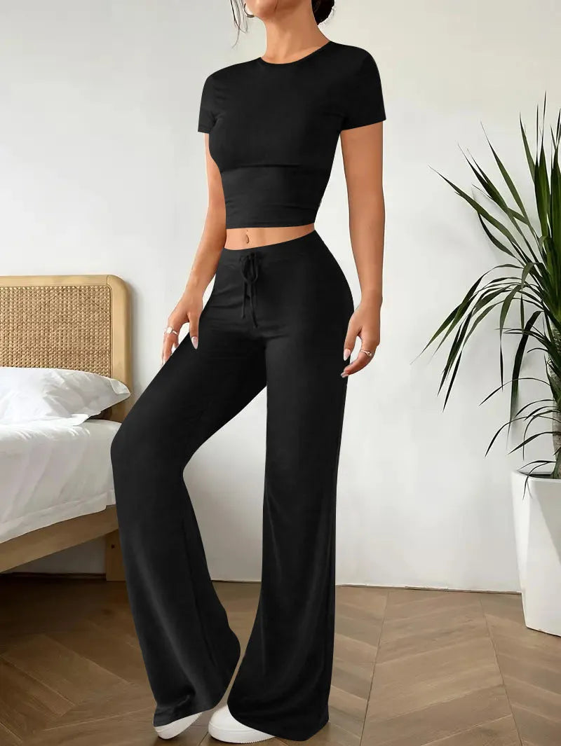 Black high-waist trousers and short-sleeve T-shirt co-ord set laid flat.