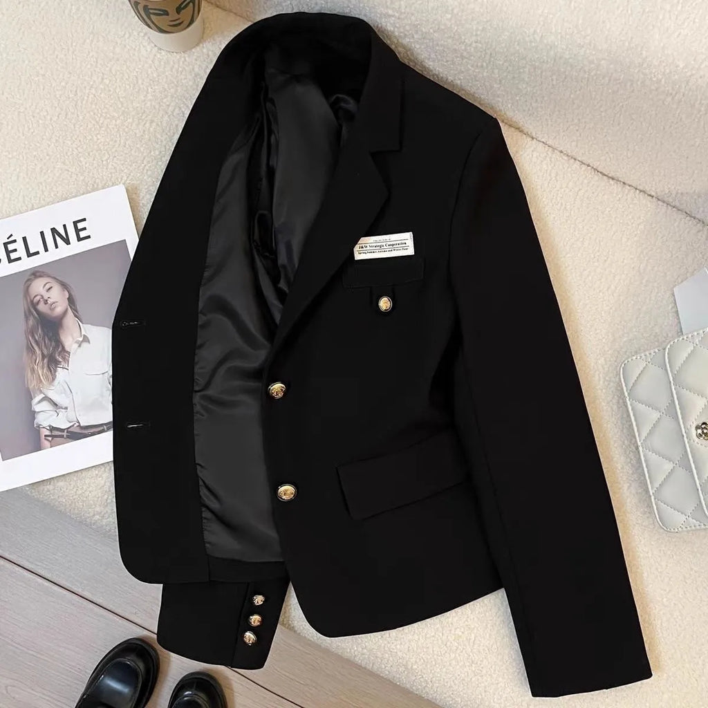 A women's black loose-fitting short suit coat with long sleeves and pockets.