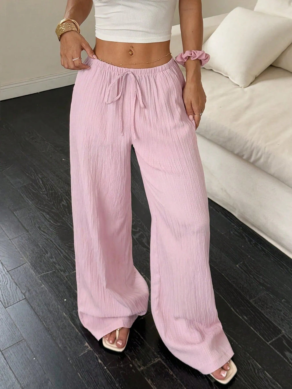 Women's black wide-leg trousers with lace-up waist detail on hanger