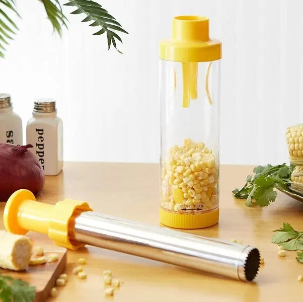 Yellow manual corn stripper thresher with stainless steel construction on a kitchen worktop.