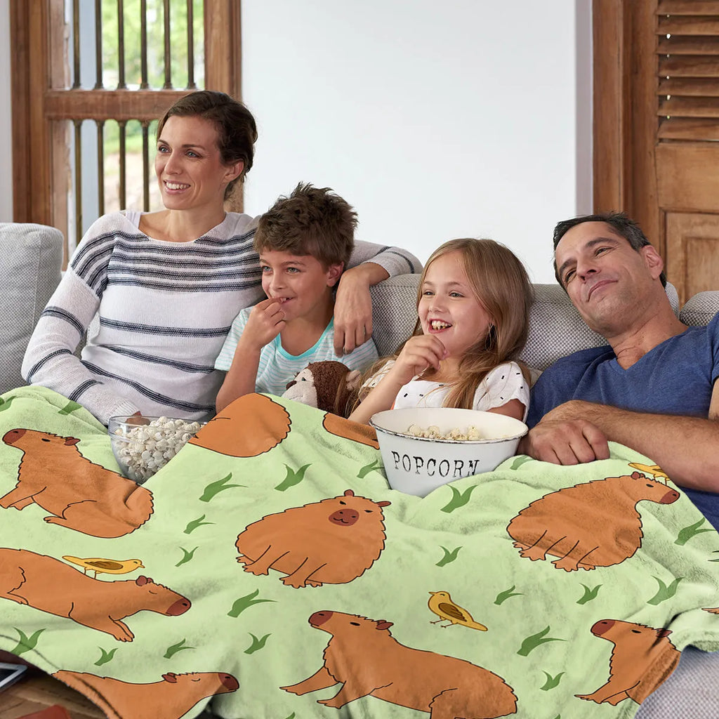 Multicolored flannel blanket with bird and capybara combined pattern on a sofa