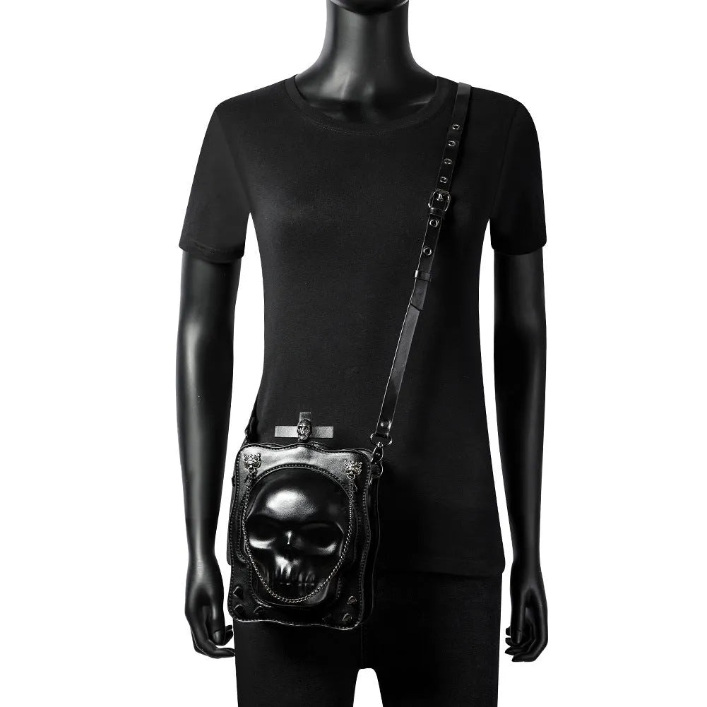 Black mini square shoulder bag with Gothic skull embossed design, chain strap, and zipper opening