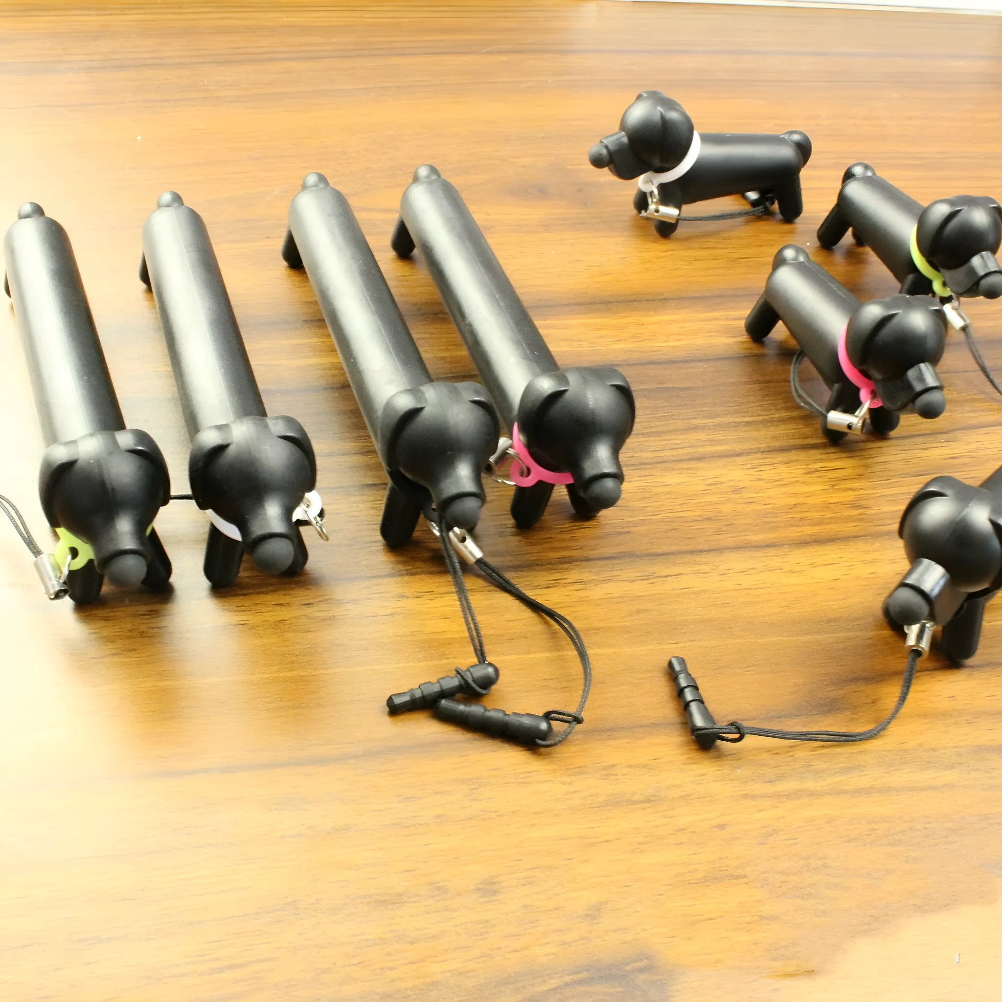 Black long puppy dog shaped touch screen stylus pen shown next to its carry socket