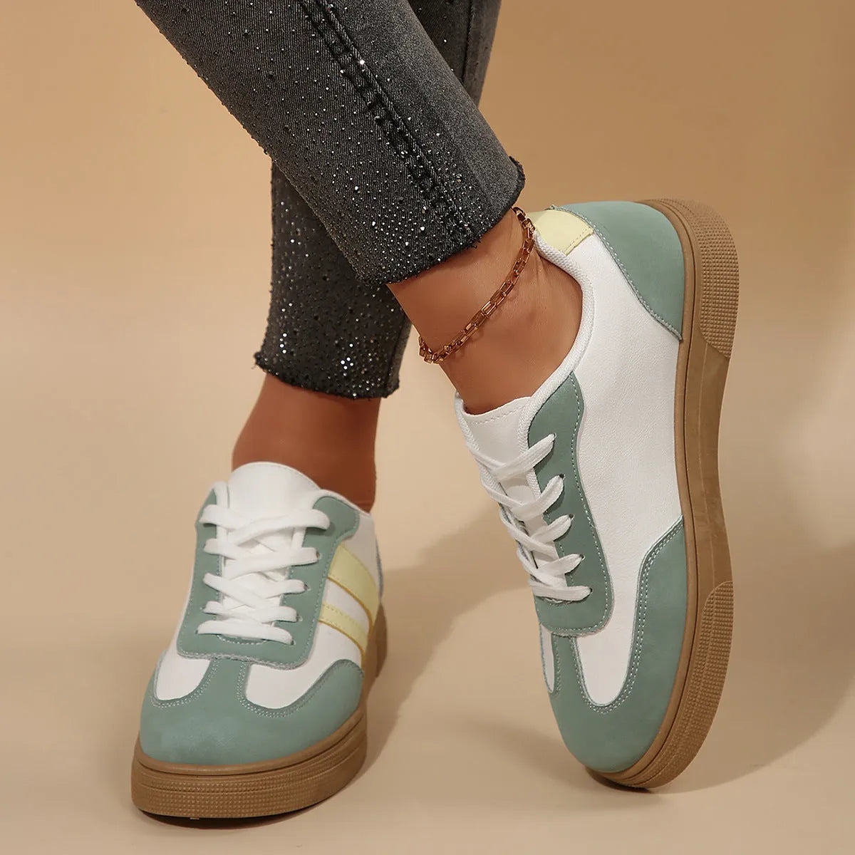Green women's retro sports pumps with cross straps, flat rubber sole, and round toe on a white background.