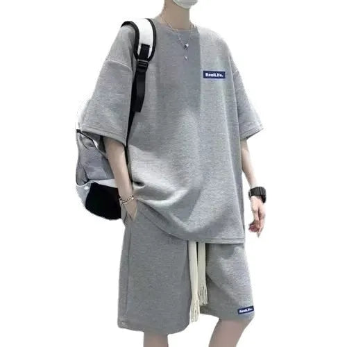 Man wearing a grey waffle-textured short sleeve leisure top and matching shorts.