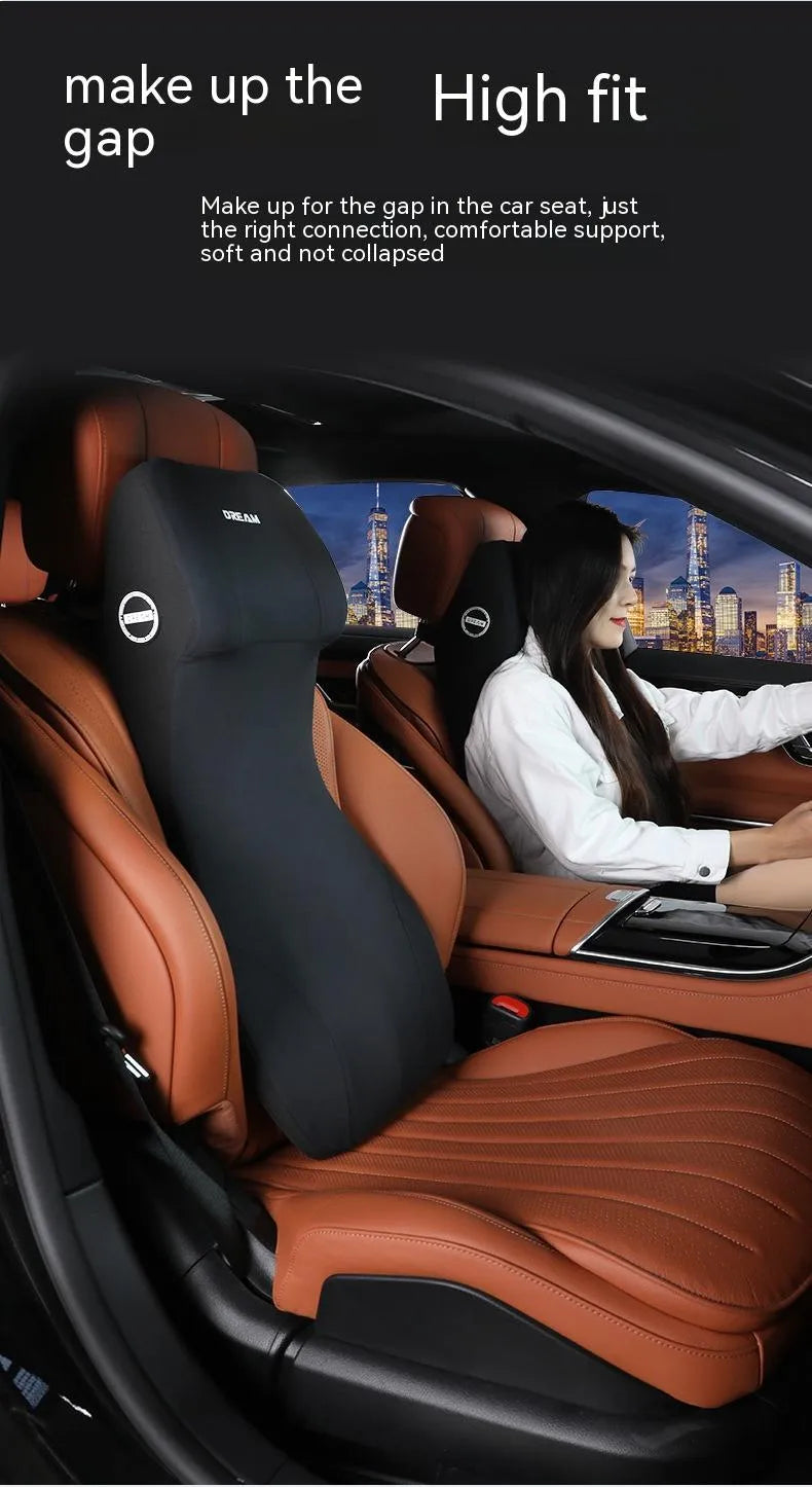 Black memory foam automotive lumbar support cushion with integrated headrest on a car seat.