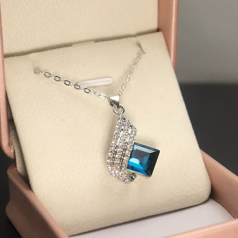 Women's jewellery set showing necklace with cross chain and matching earrings with glass elements