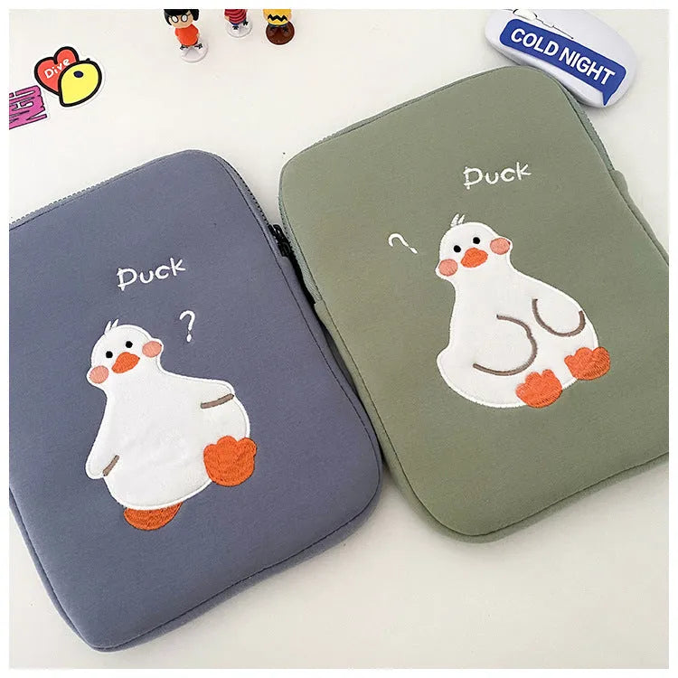 Blue cotton tablet case with embroidered cartoon duck design and a zipper, sized for an iPad.