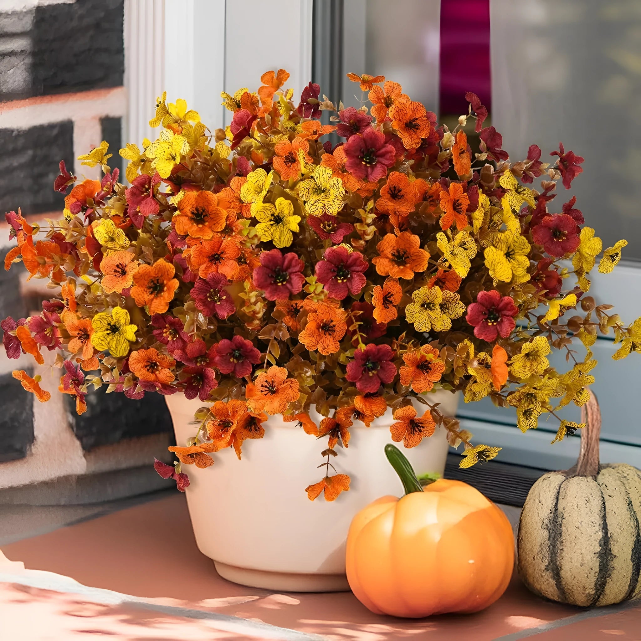 Plastic and silk artificial flower bouquet in autumn colours of red, yellow, orange and orange-yellow.