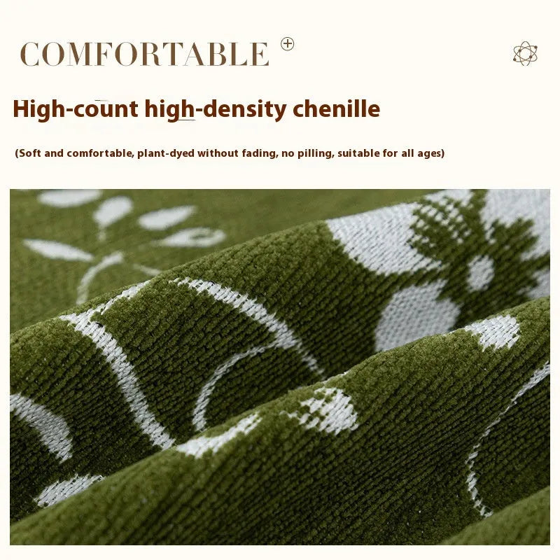 Chenille sofa cover with embroidered magnolia pattern in garland black, coffee, and green colours